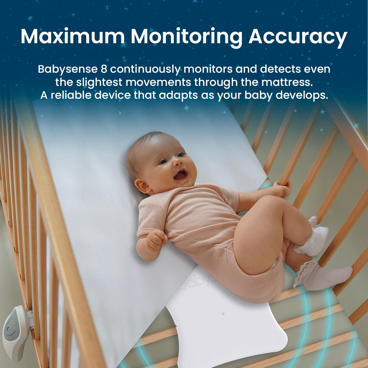 A smiling baby in a light-colored onesie lies on a white mattress in a wooden crib, with a white Babysense 8 monitor visible beneath the mattress, illustrating its continuous monitoring and detection of even the slightest movements, making it a reliable wireless baby monitors full hd system