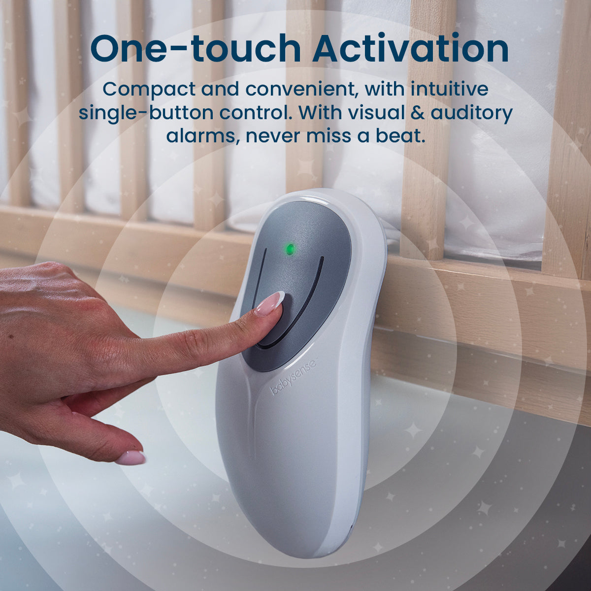 A hand with manicured nails presses the single button of the white Babysense 8 device with a green indicator light, which functions as a baby monitor, attached to a wooden crib
