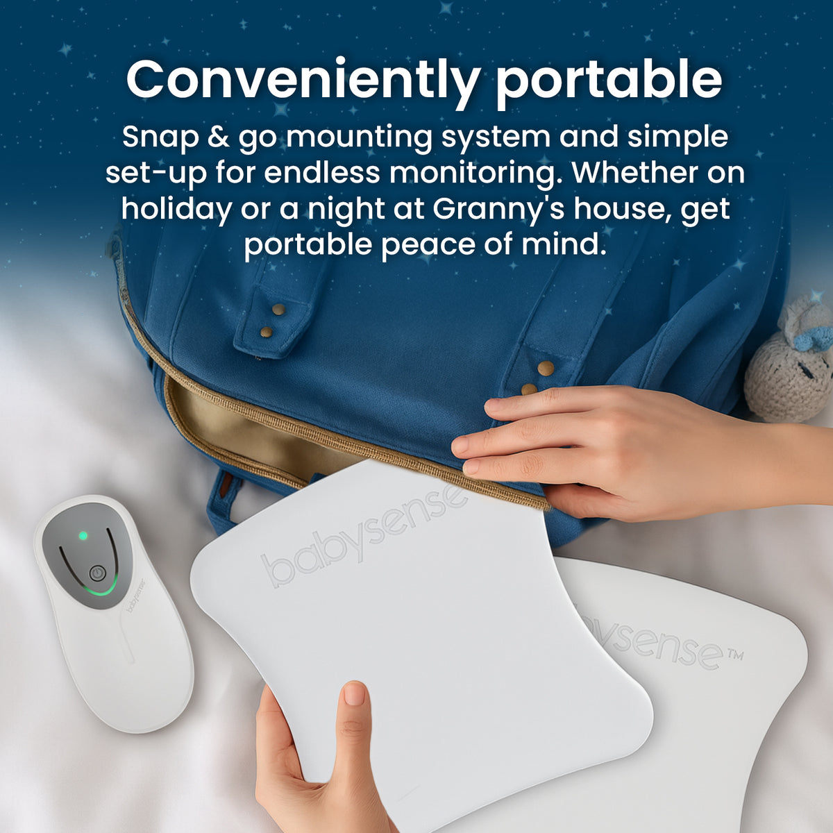 A person's hands are placing a white Babysense 8 control unit and thin sensor pads, which are a portable baby monitor for travel, into a blue diaper bag
