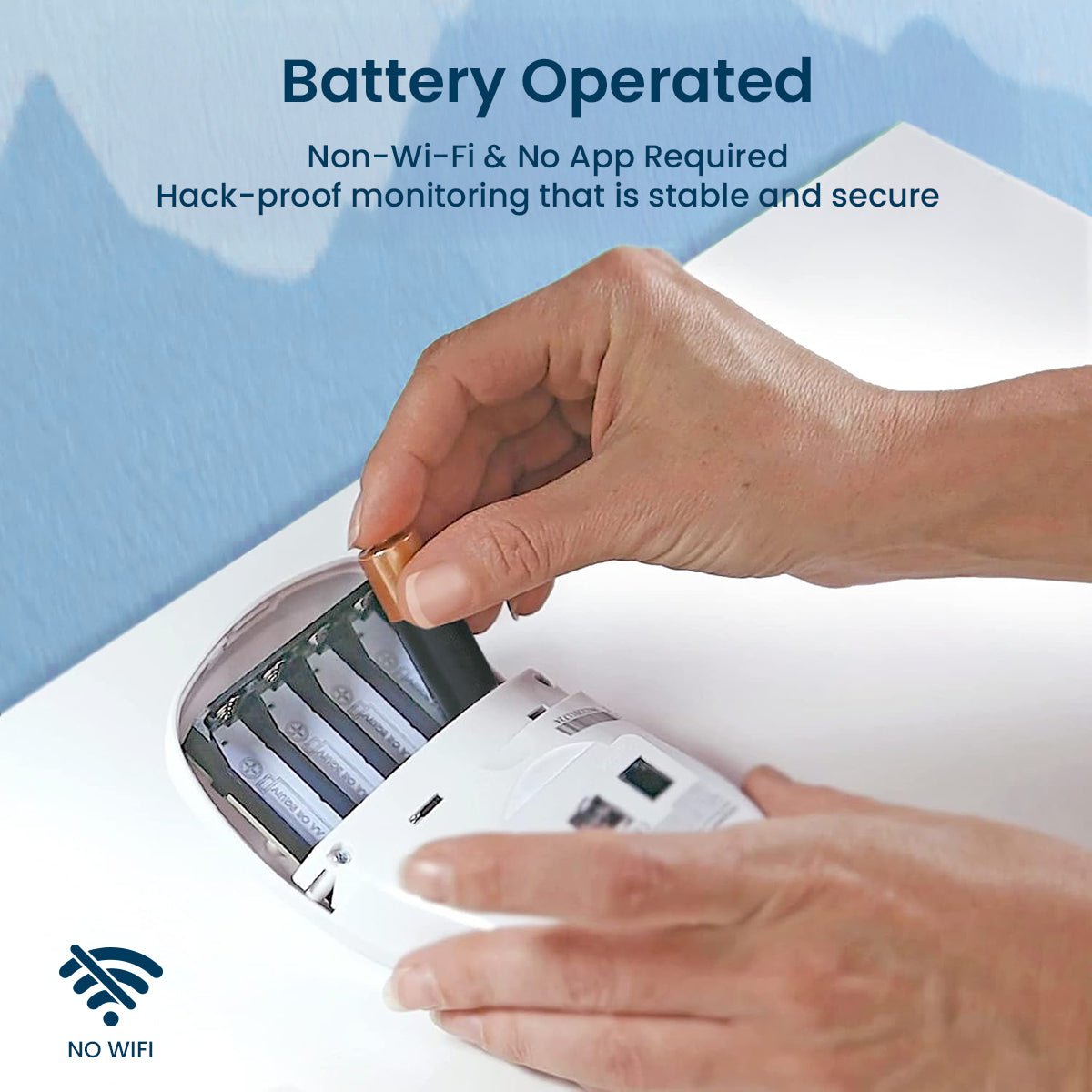 A person's hands are inserting a battery into the white Babysense 7 - Baby Monitor with Breathing Motion Detection & Safety Alerts unit, highlighting its battery-operated, wireless functionality as a baby wireless hd camera
