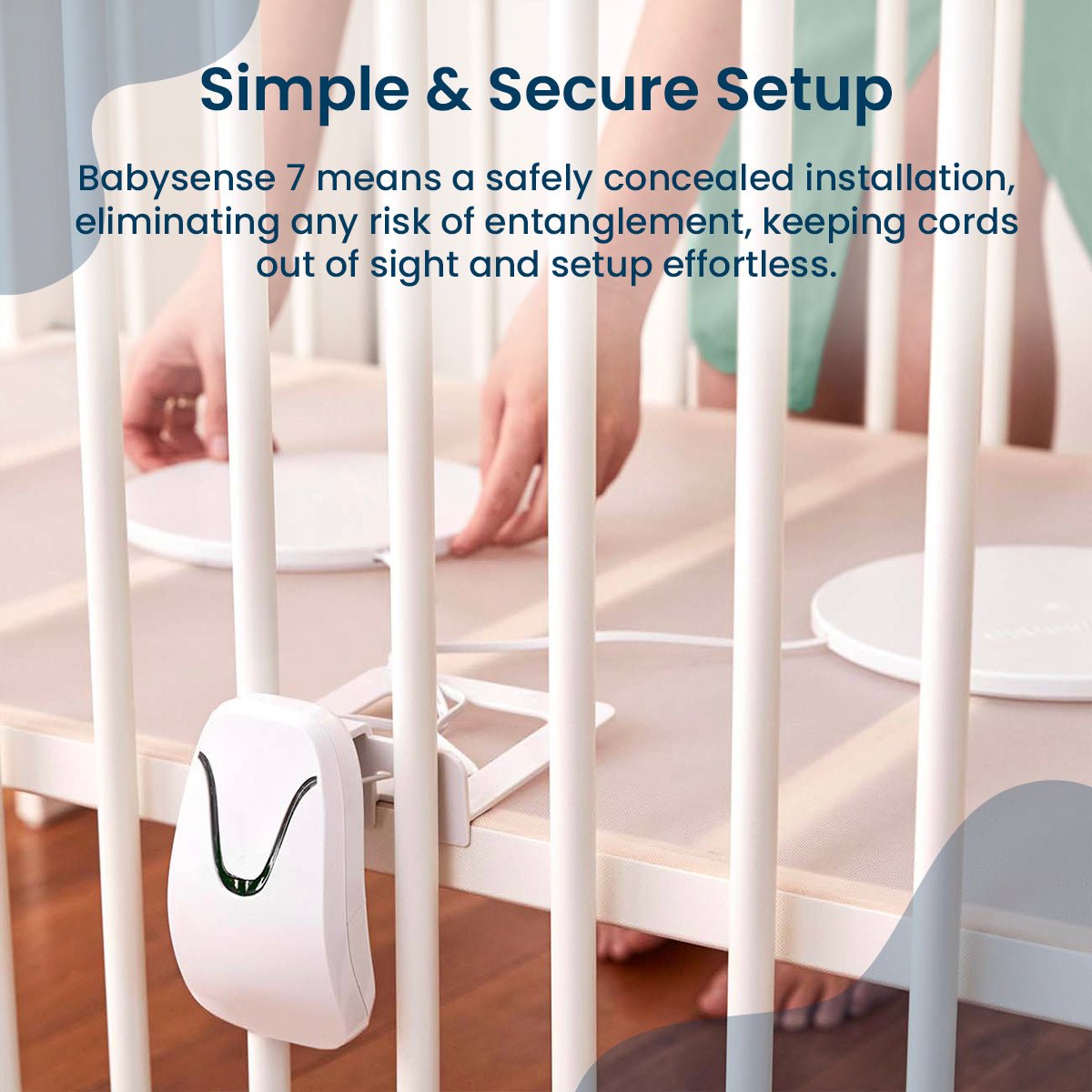 A person's hands arrange the flat sensor pads of the Babysense HOME 2-in-1 Monitoring Set under a crib mattress, showcasing a baby monitor that connects to phone without wifi