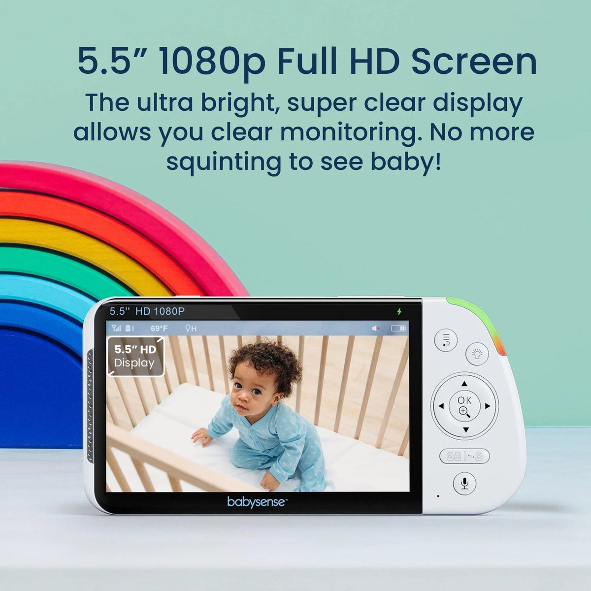 A white Babysense Dreamer 2.0 & Pro wireless baby monitors full hd screen displays a baby in a crib, with a colorful rainbow toy in the background