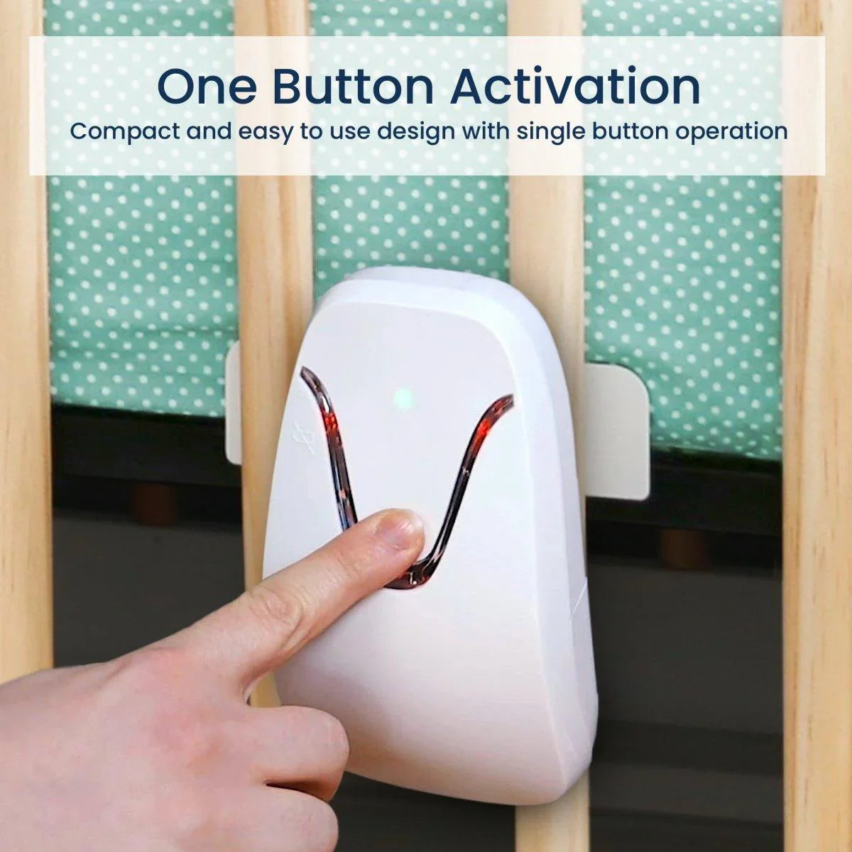 A hand presses a button on the white Babysense 7 & V24 video baby monitor with breathing motion detection, which is attached to a light wood crib with a green polka dot sheet