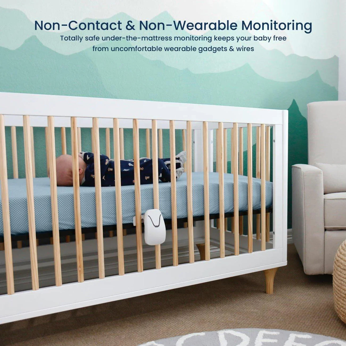 A Babysense True Sleep video baby monitor, a white under-the-mattress device, is clipped to a baby's white crib with light wood slats in a nursery